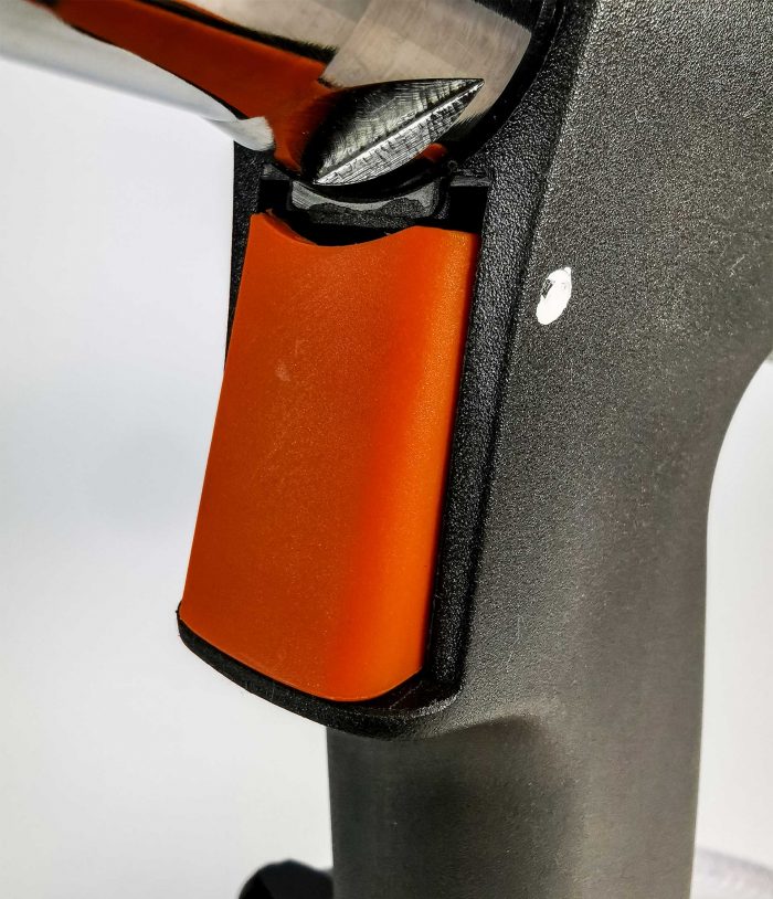 Zbliżenie na spust nitownicy pneumatycznej AIR POWER 1 w pomarańczowym kolorze, umieszczony w ergonomicznym uchwycie urządzenia.